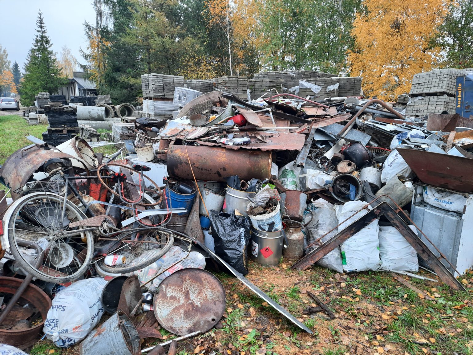 Zbiórka złomu składająca się z różnych przedmiotów, w tym starych rowerów i metalowych pojemników. Użyteczna informacja dla osób poszukujących materiałów do recyklingu lub napraw.