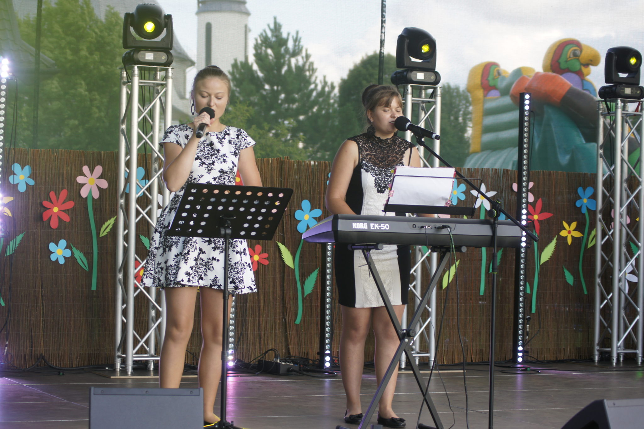 Dwie osoby wykonują muzykę na scenie podczas wydarzenia IV Dzień Rodziny.